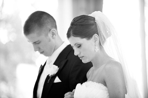 the bride and groom bowing their heads in prayer - photo by Houston based wedding photographer Adam Nyholt